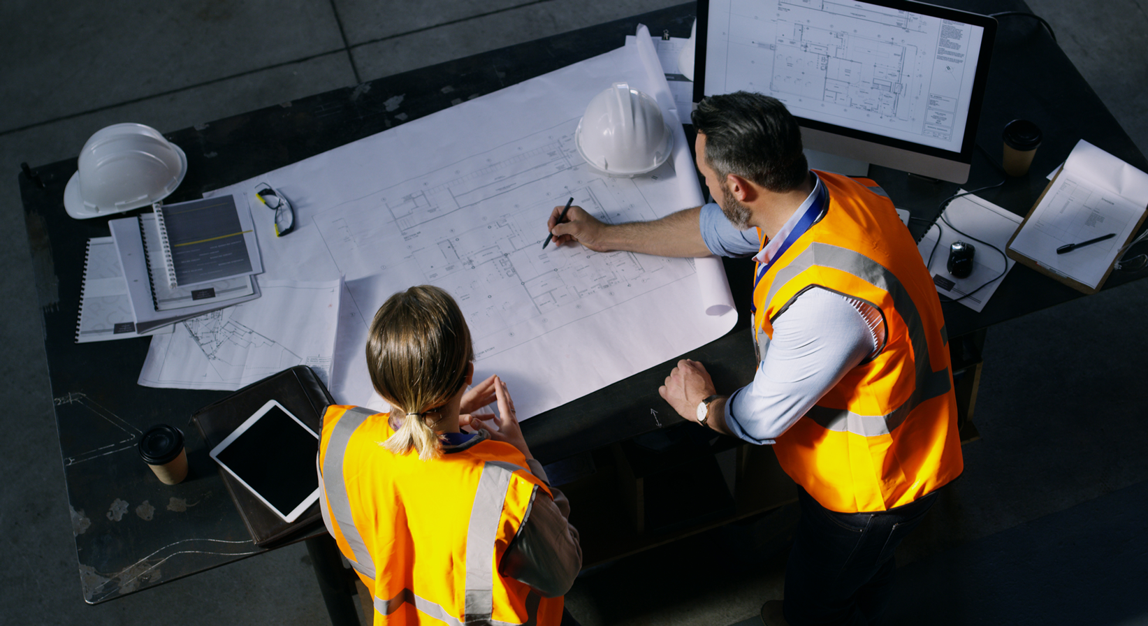 A pair of construction workers looking at a building plans