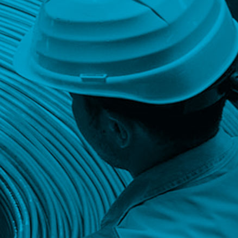 A worker in a safety hat looking at materials
