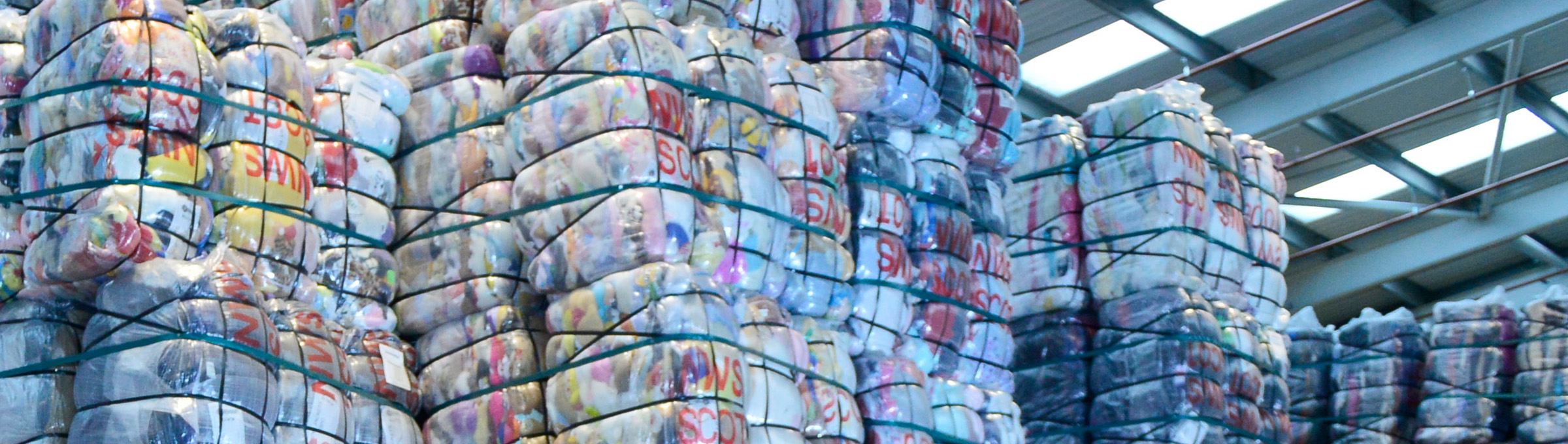 Large bales of clothing in a warehouse