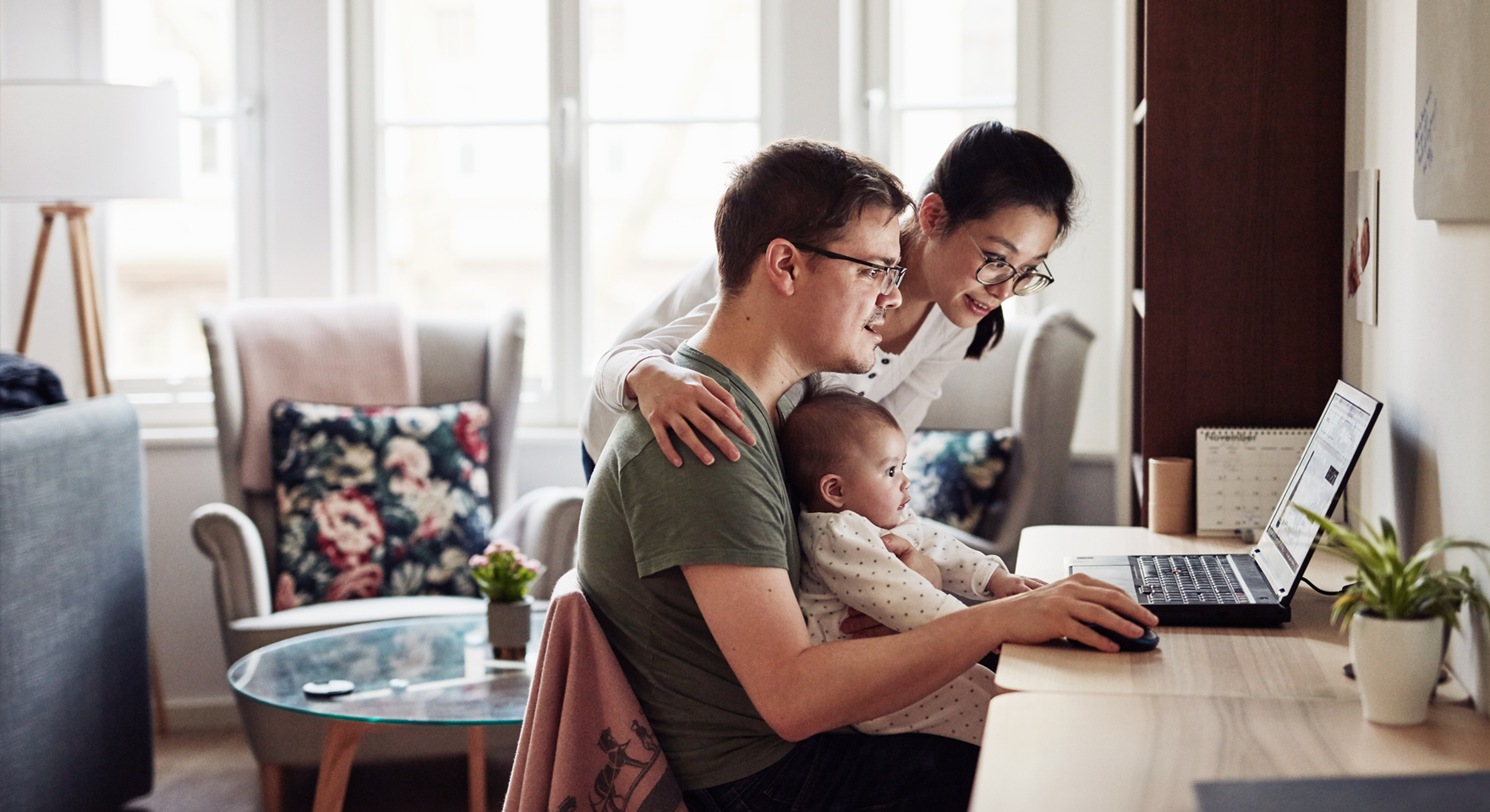 A family sitting in front of a computer reading and learning