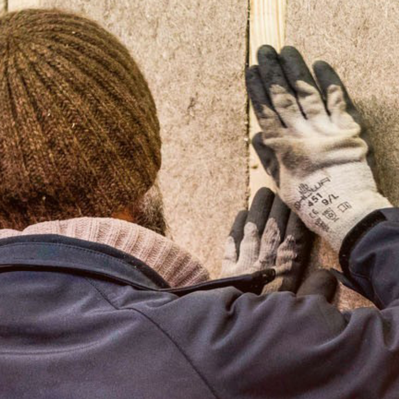 A person working to install construction materials