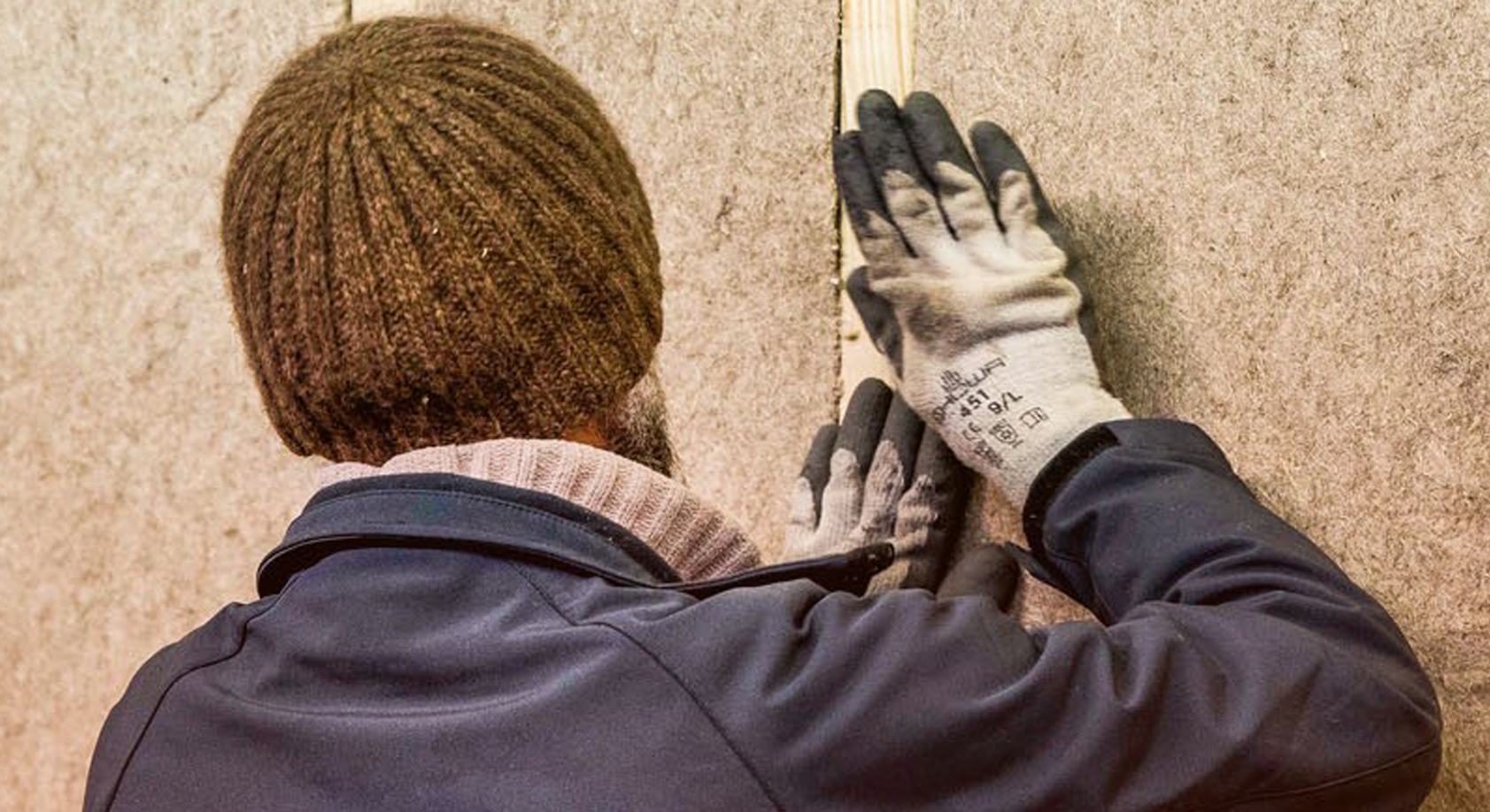 A person working to install construction materials