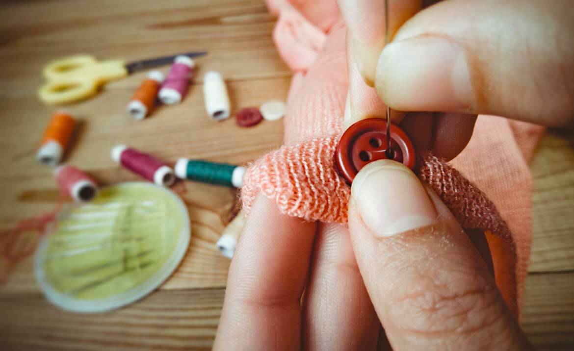 Person sewing on a button