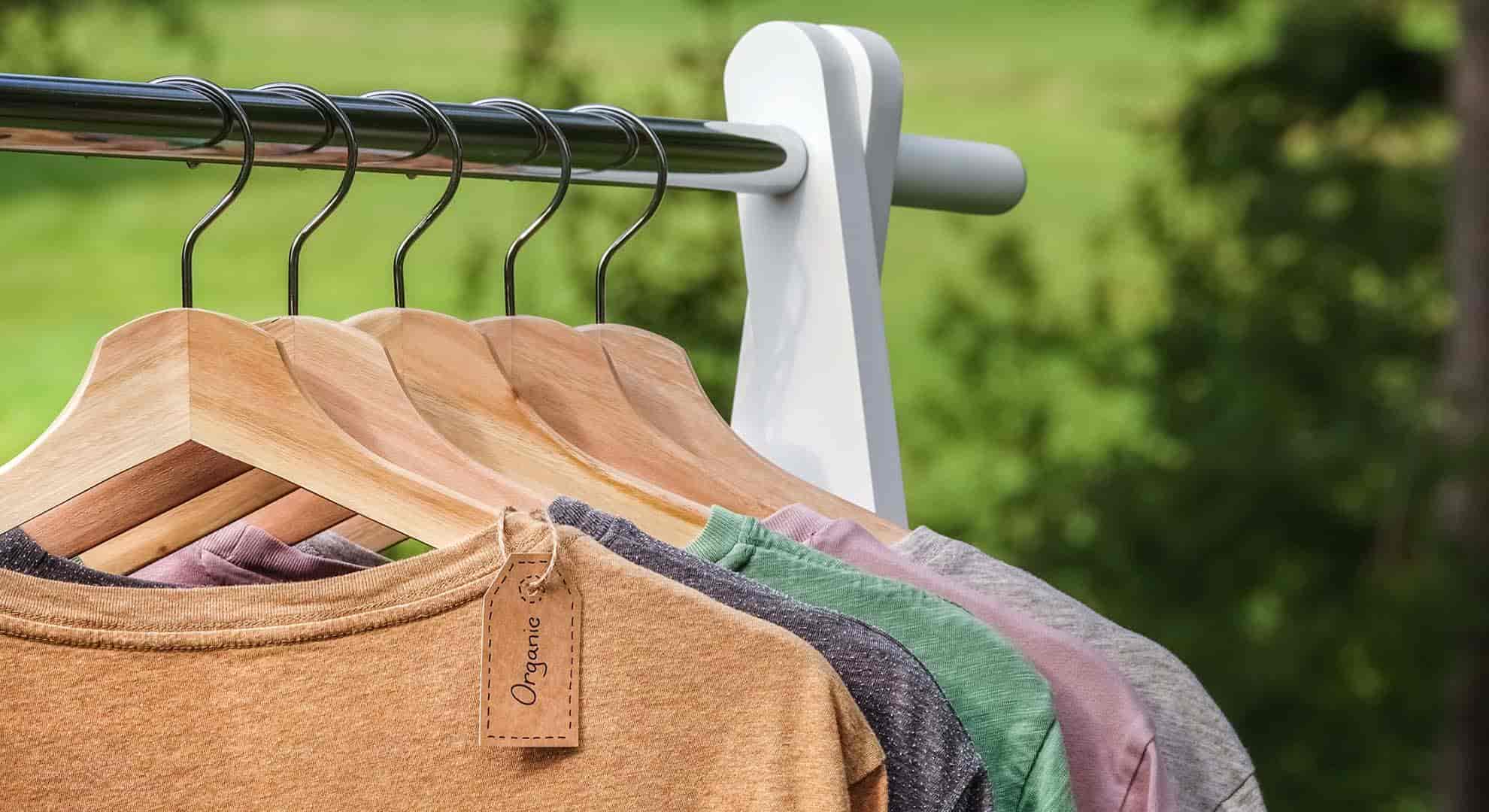 Photo of organic cotton tshirts on wooden hangers - greenwashing in fashion.jpeg