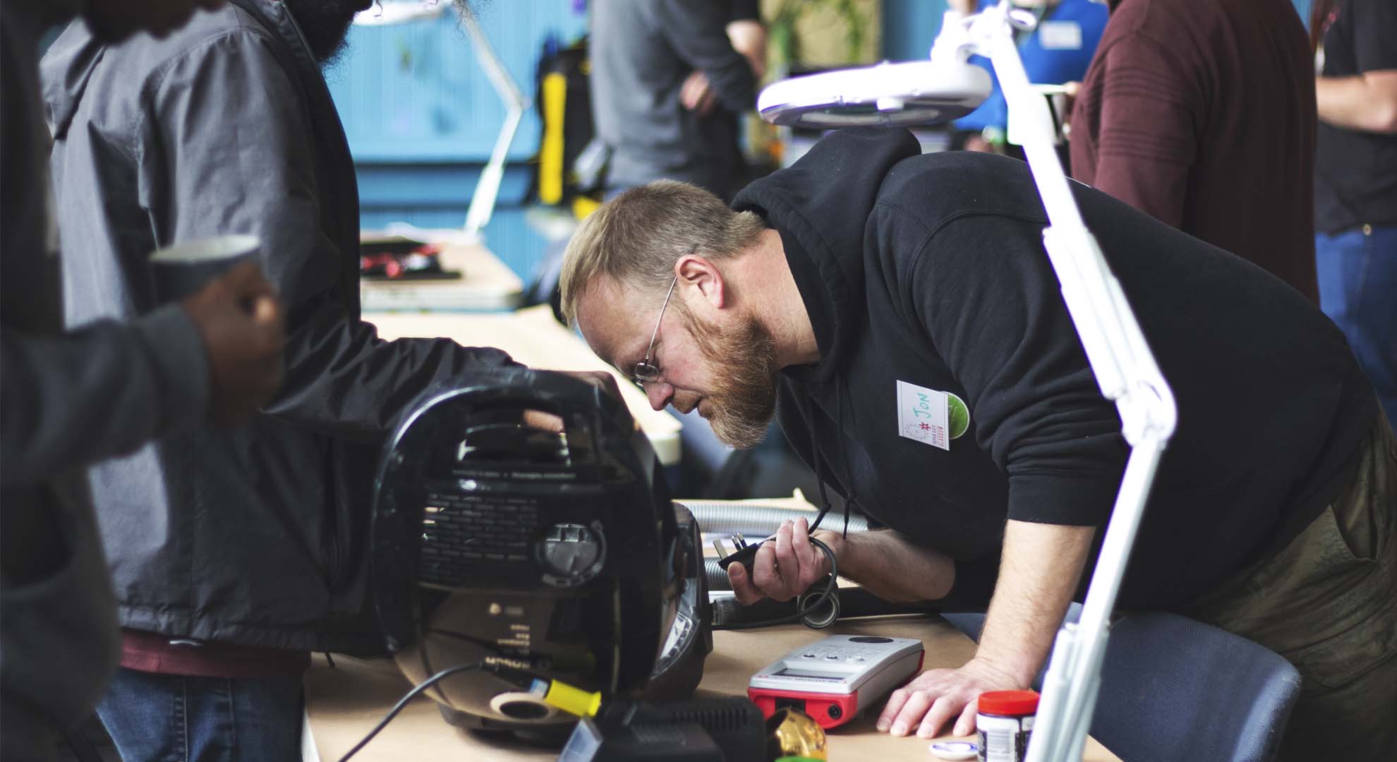 A person working to repair electrical devices at a repair cafe
