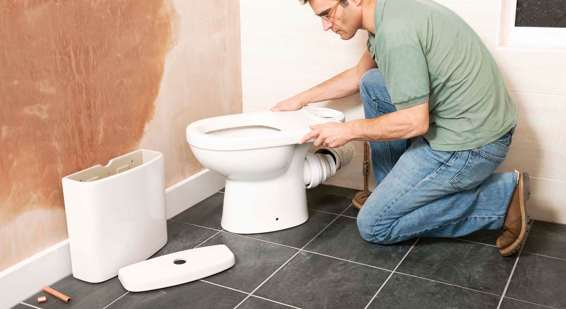 A person working to remove a toilet 