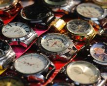 Multiple watches are shown on a colourful background 