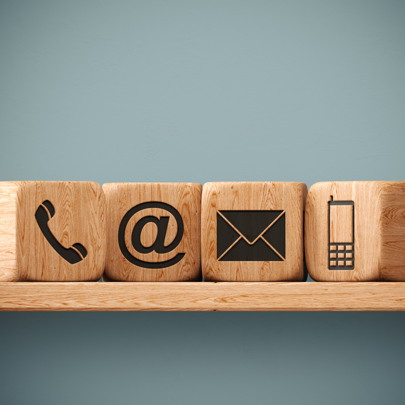 An abstract image showing wooden blocks with symbols on them for phone, email and mail.