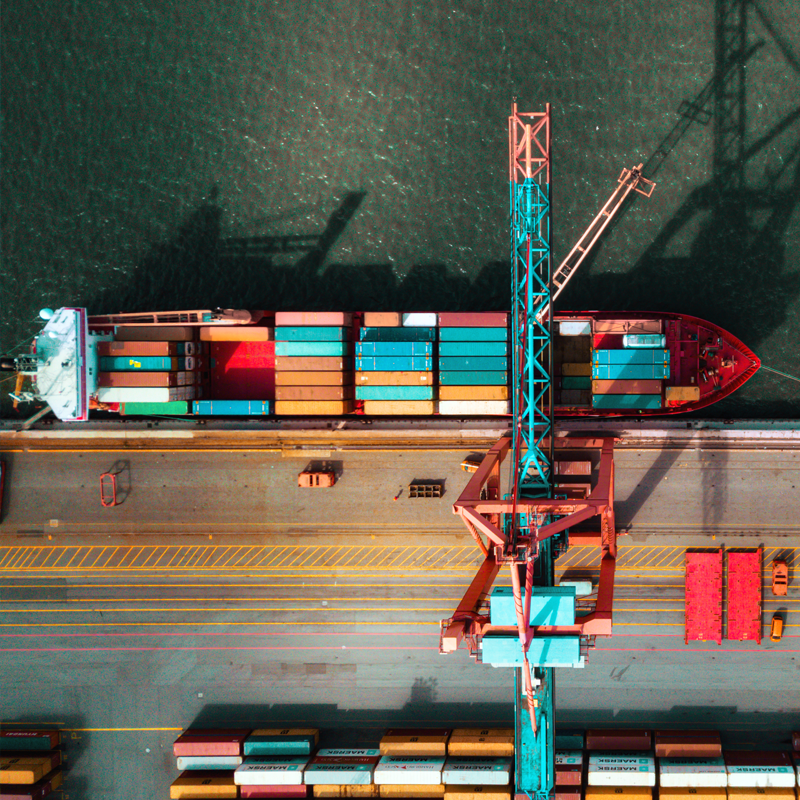 A high altitude shot of shipping containers arriving at a port