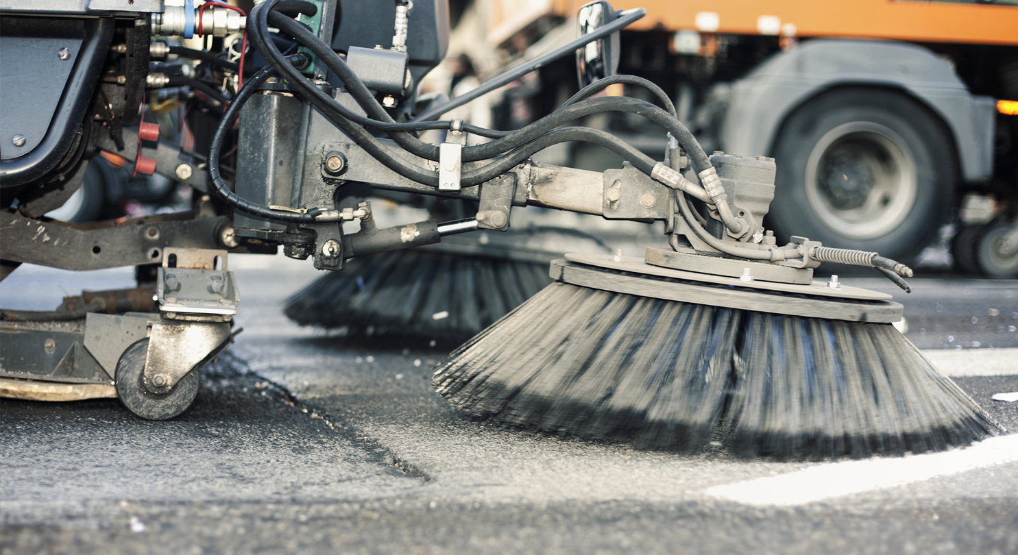 A street sweeper machine cleaning a street with litter