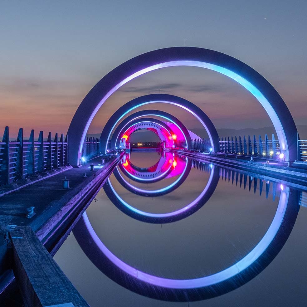 Photo looking across the rings of the Falkirk wheel lit up at dusk.