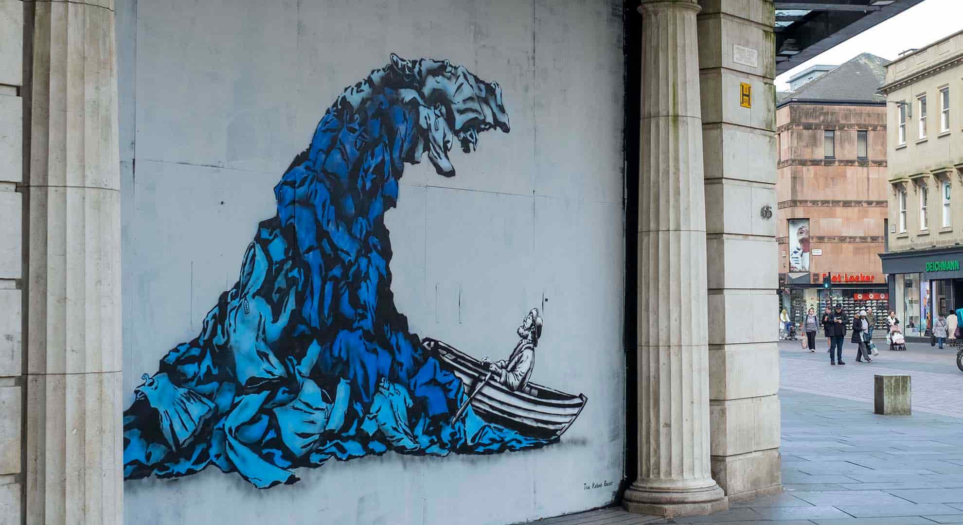 Street art depicting a wave of clothing created by The Rebel Bear in Glasgow Scotland