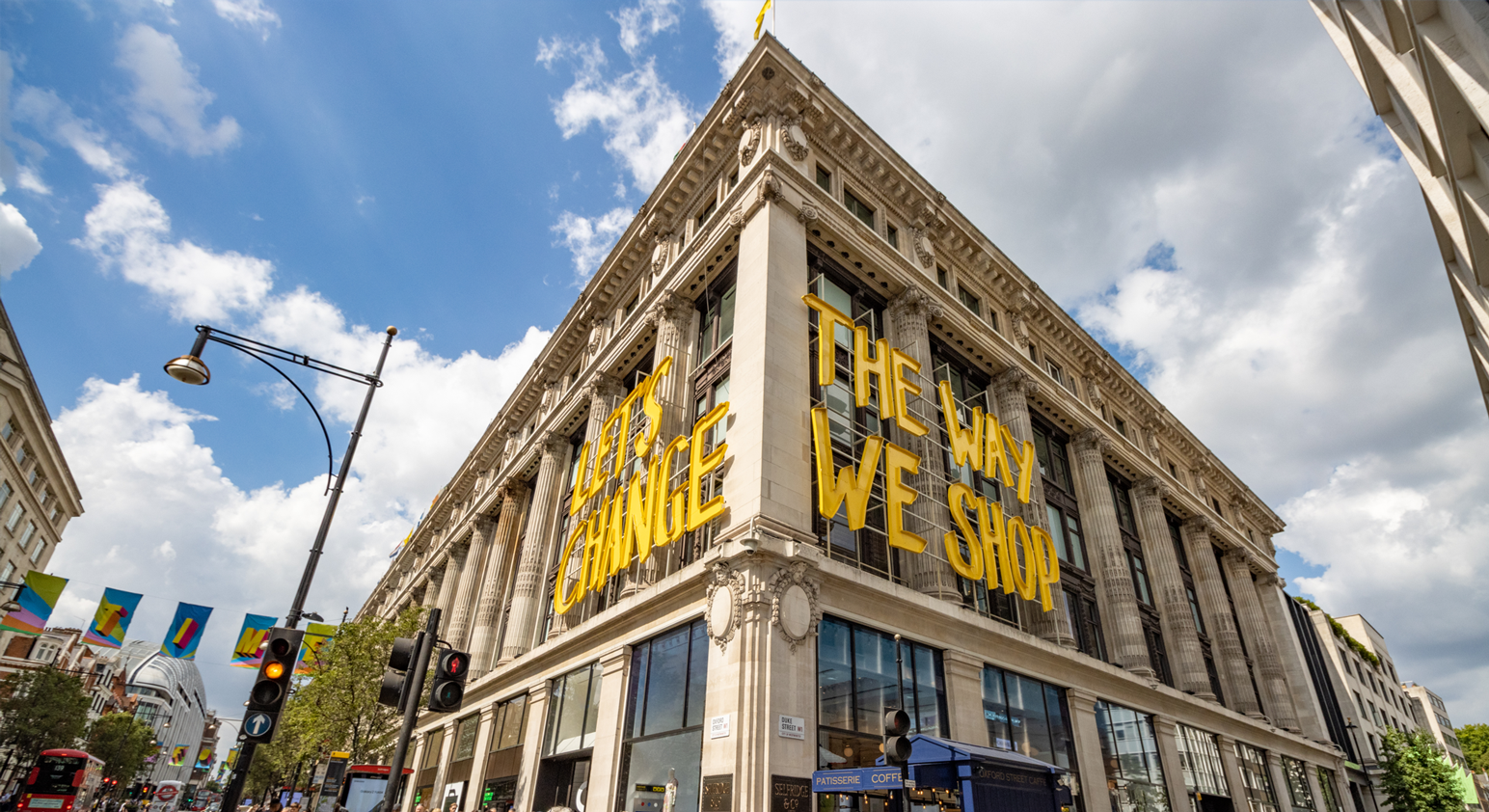 The outside of a large shop building, with the text "Let's change the way we shop"