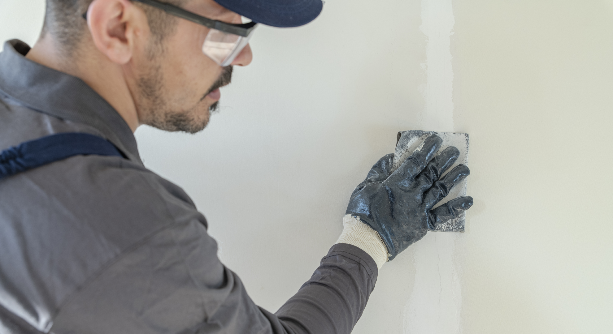 A person installing plasterboard in a building