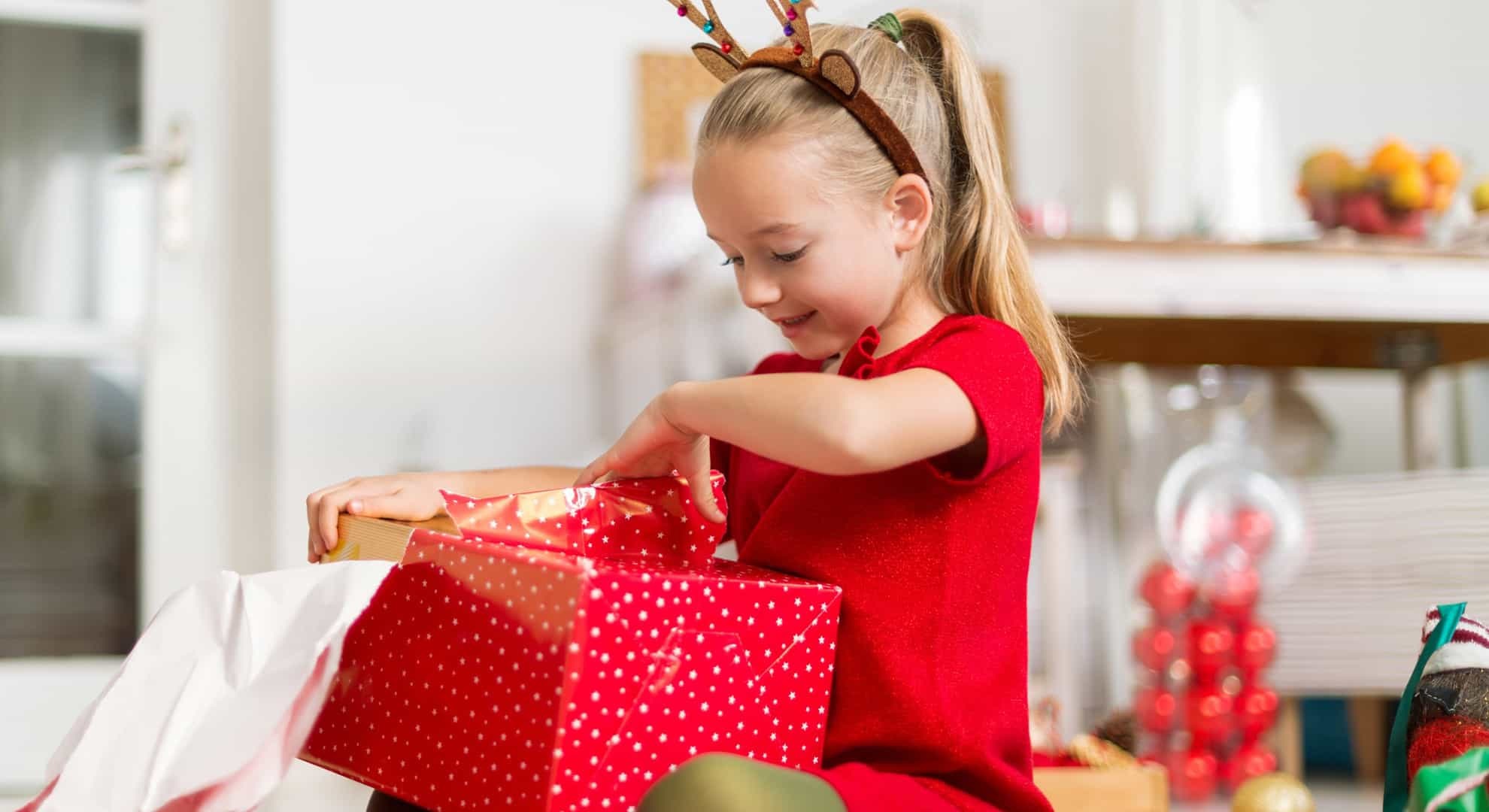 child tearing open presents on christmas morning