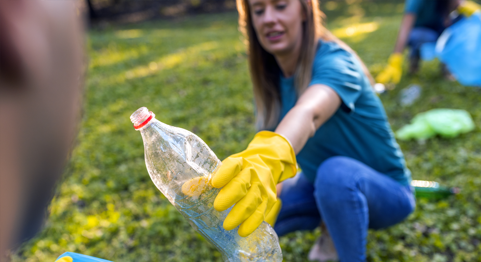 A person bending over to pick up litter