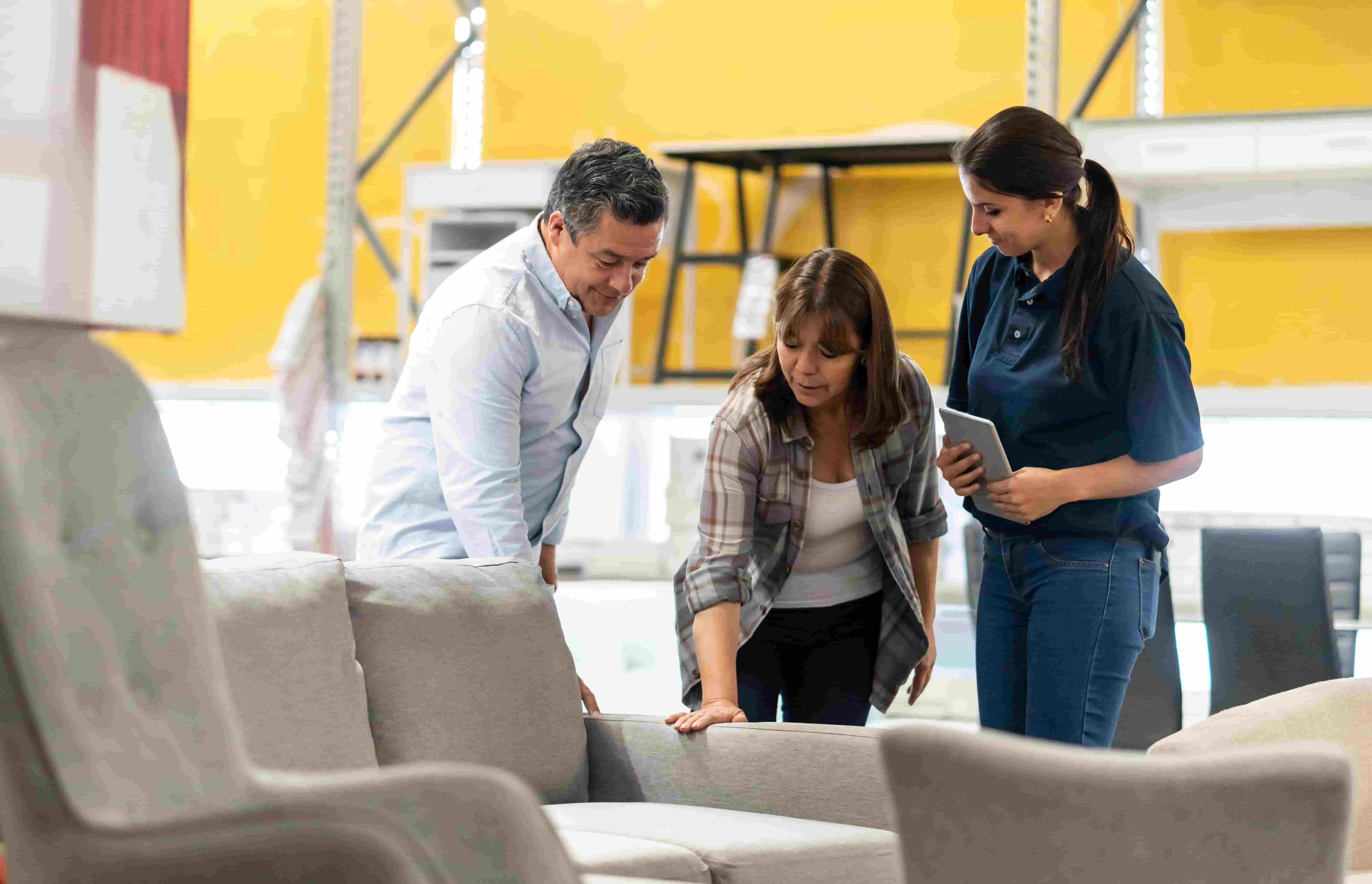 sales woman helping customers shop for a sofa