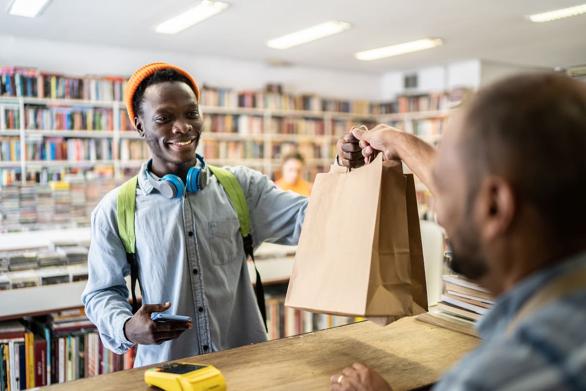 young man paying in a thrift store