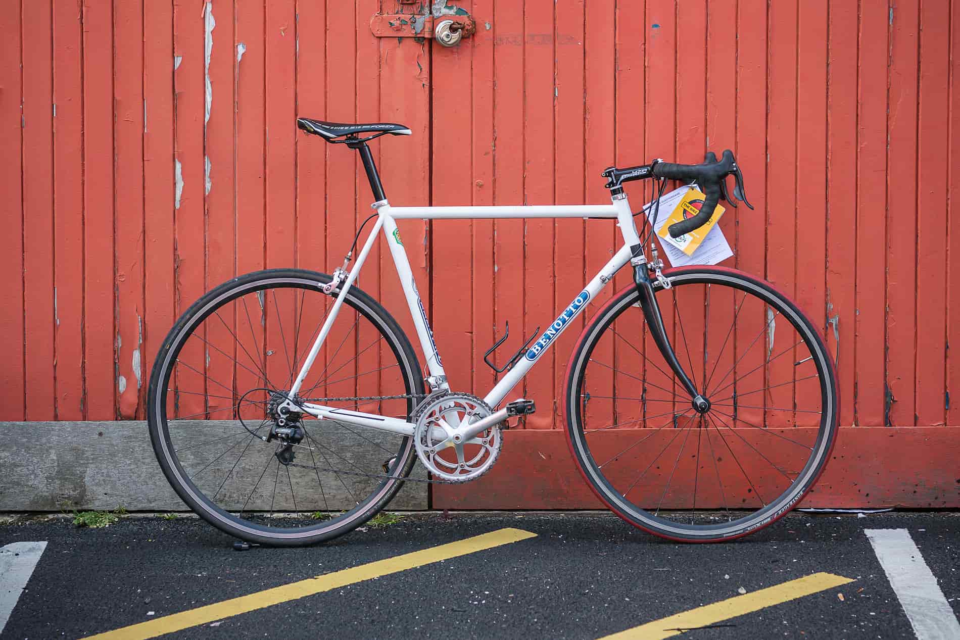 second hand bike in front of an orange door