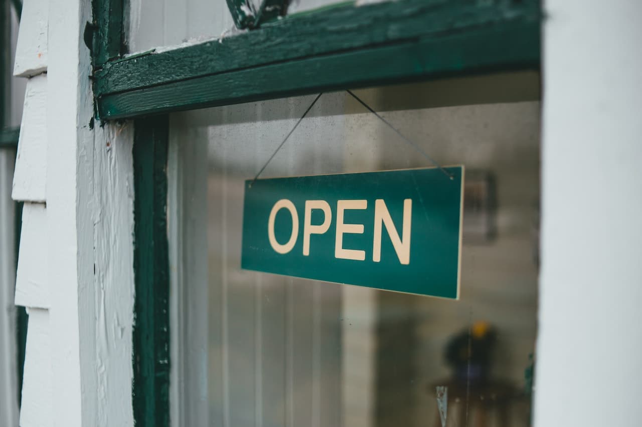 A Blue Open Sign on the Window