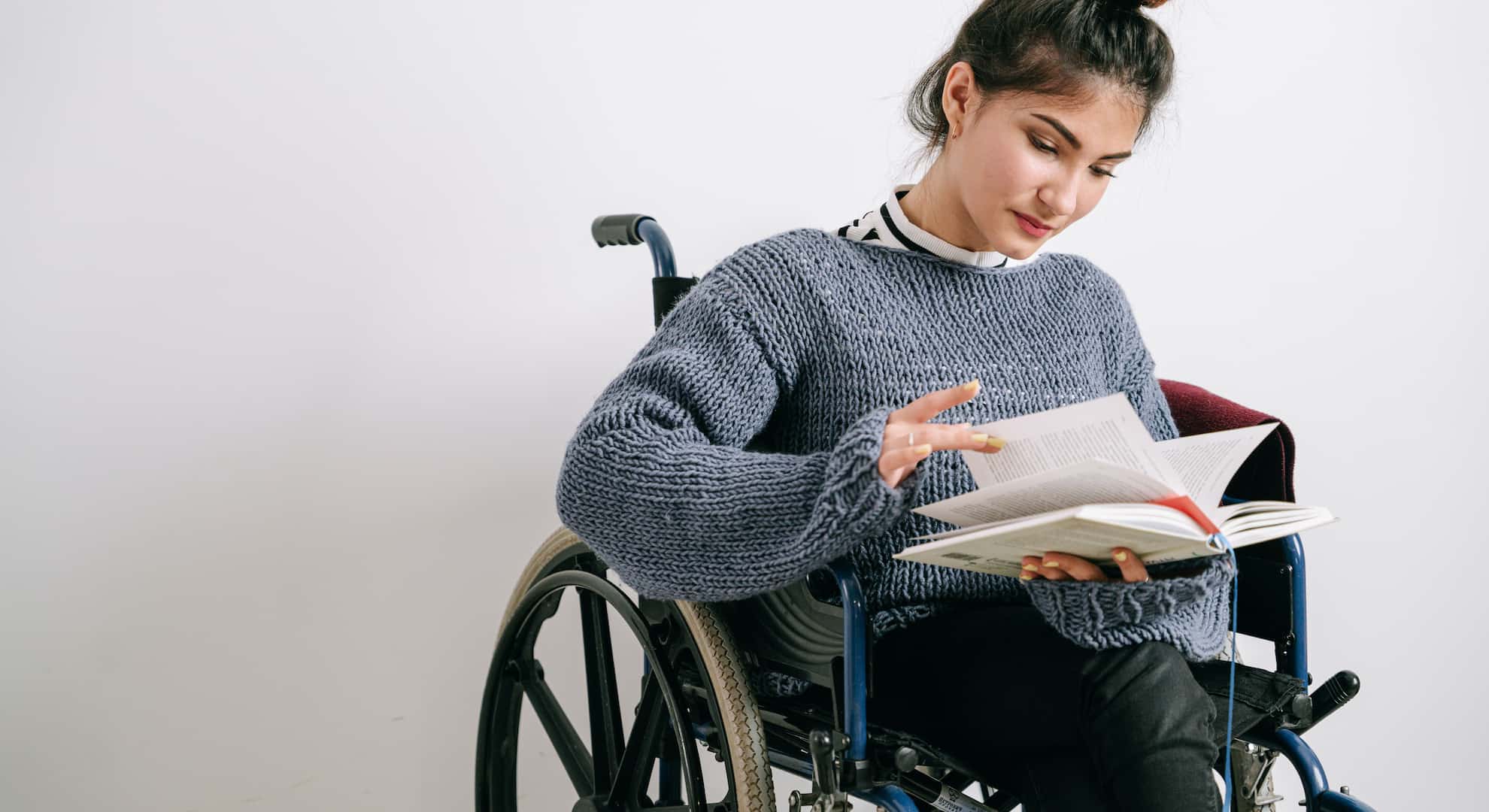 Woman in a wheelchair reading a book