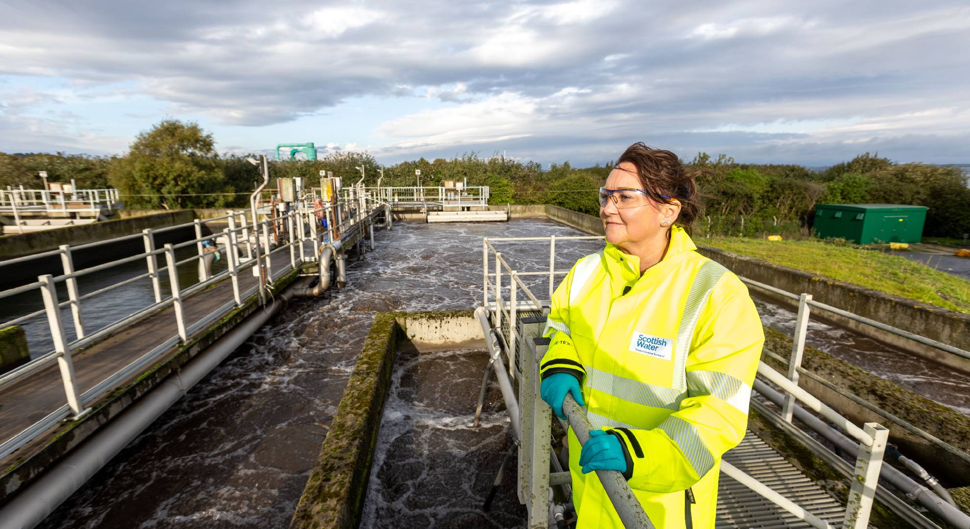 Woman in hivis jacket looking at water