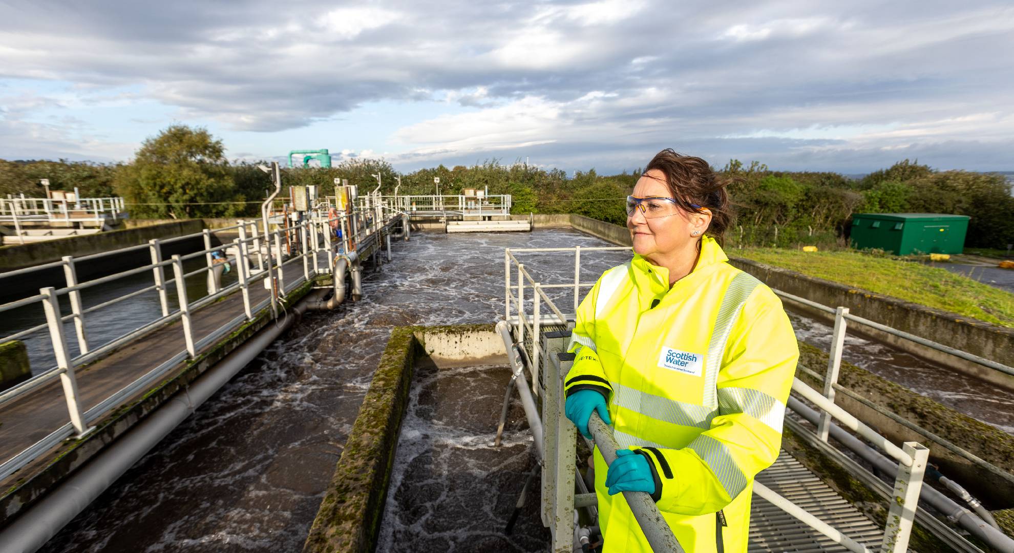 Woman in hi-vis jacket looking at water