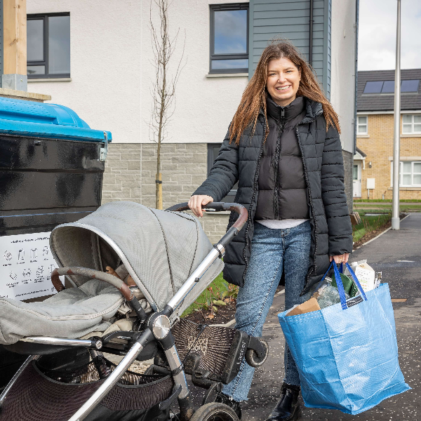 Person with family recycling in a communal bin