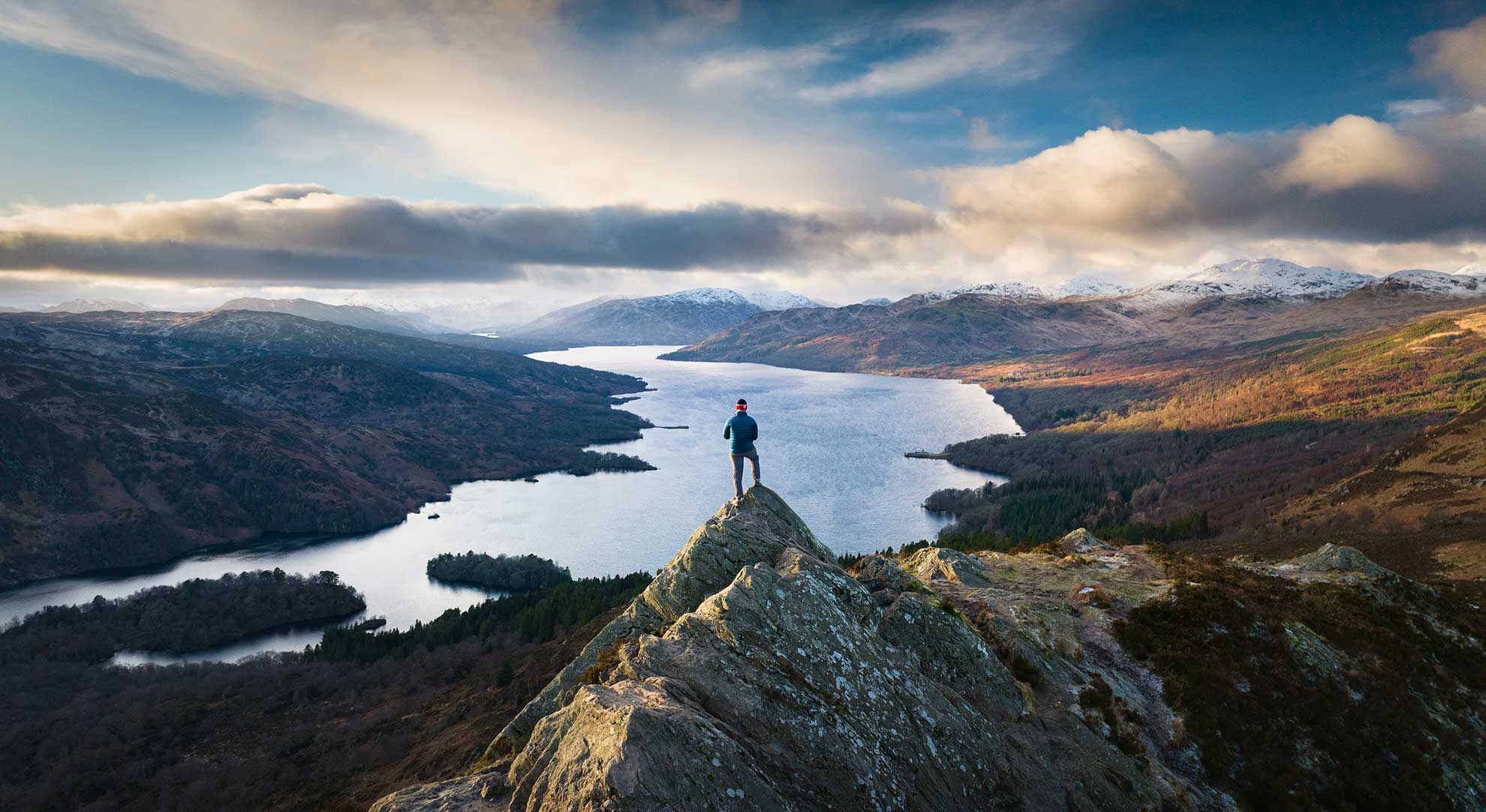 Mountain climber overlooking scottish mountain view