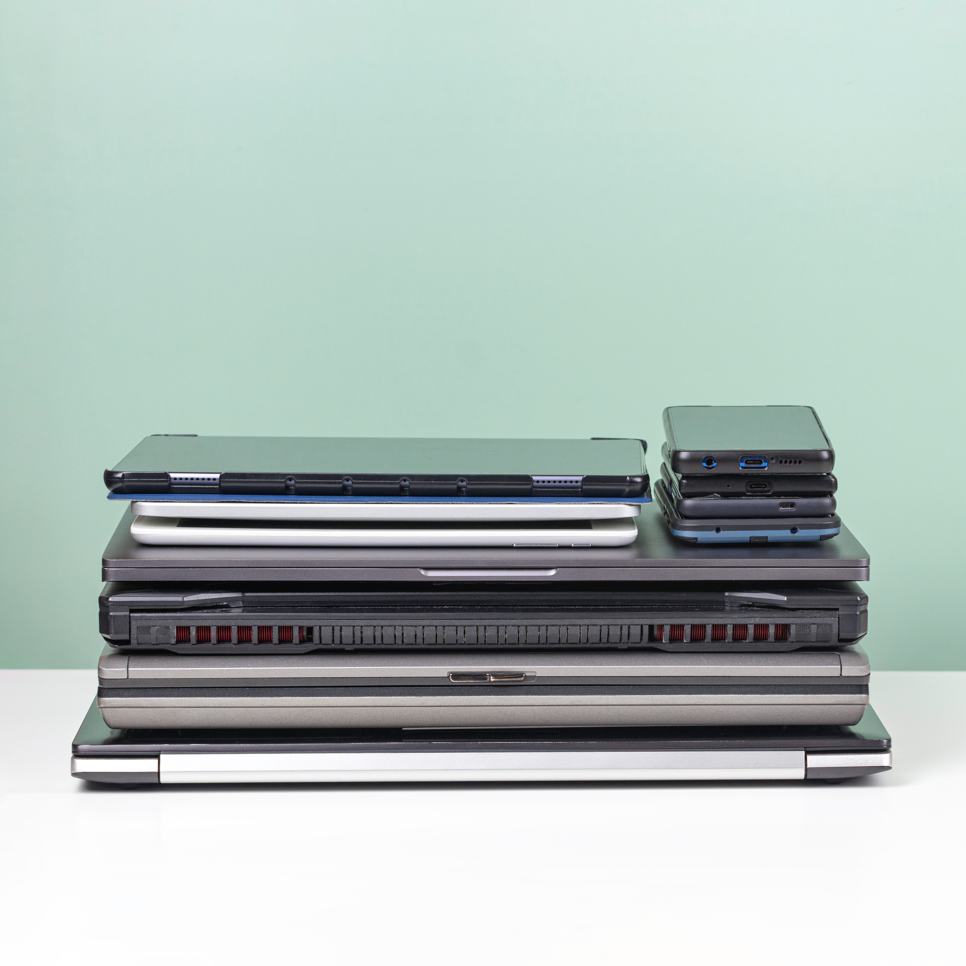 A stack of laptops and mobile phones