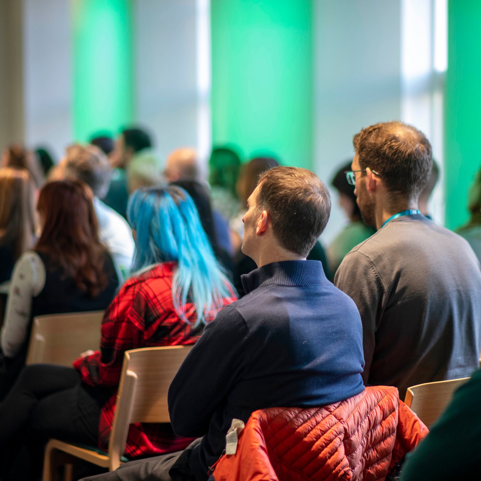 A group of people sitting watching a presentation