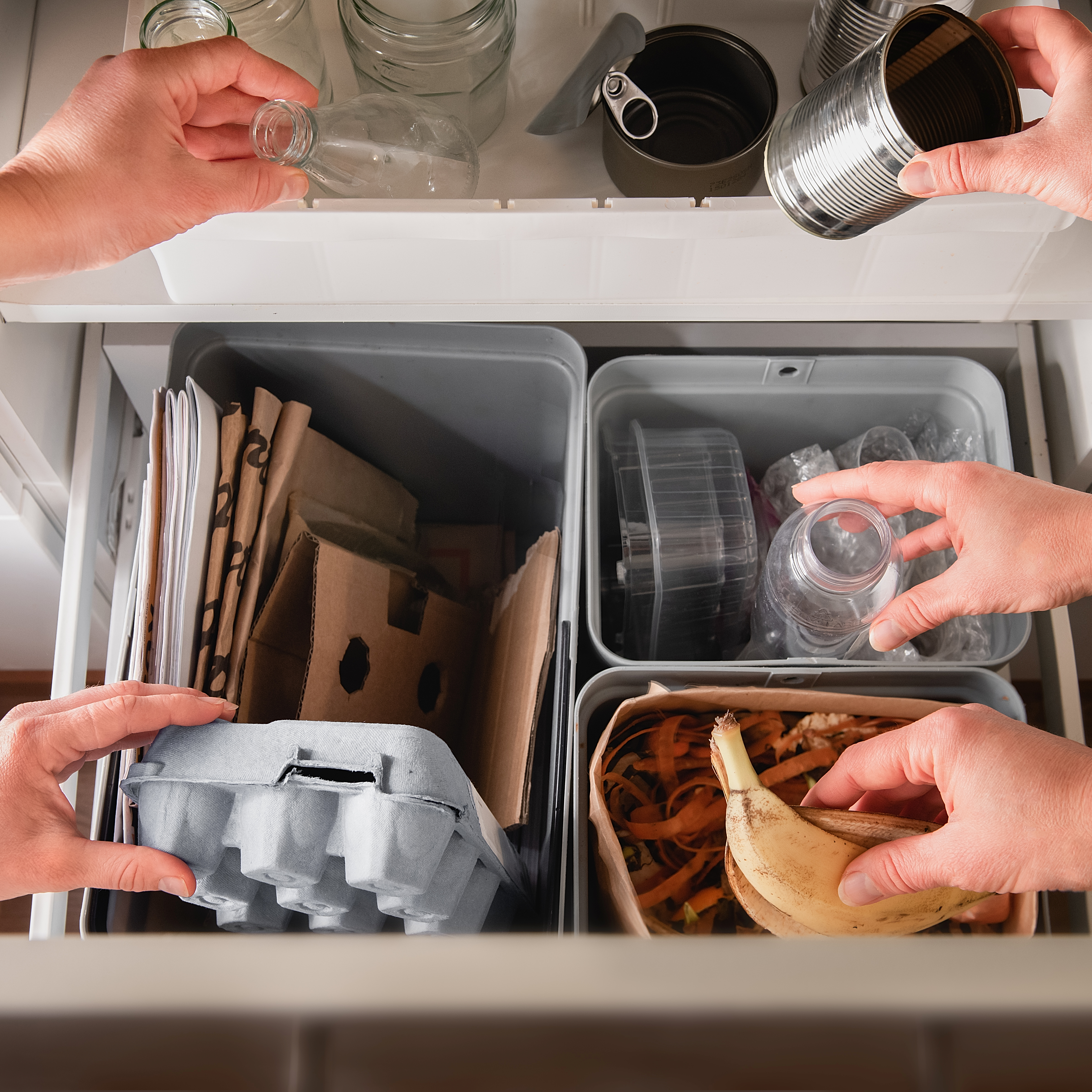 two people sorting recycling in to relevant household bins