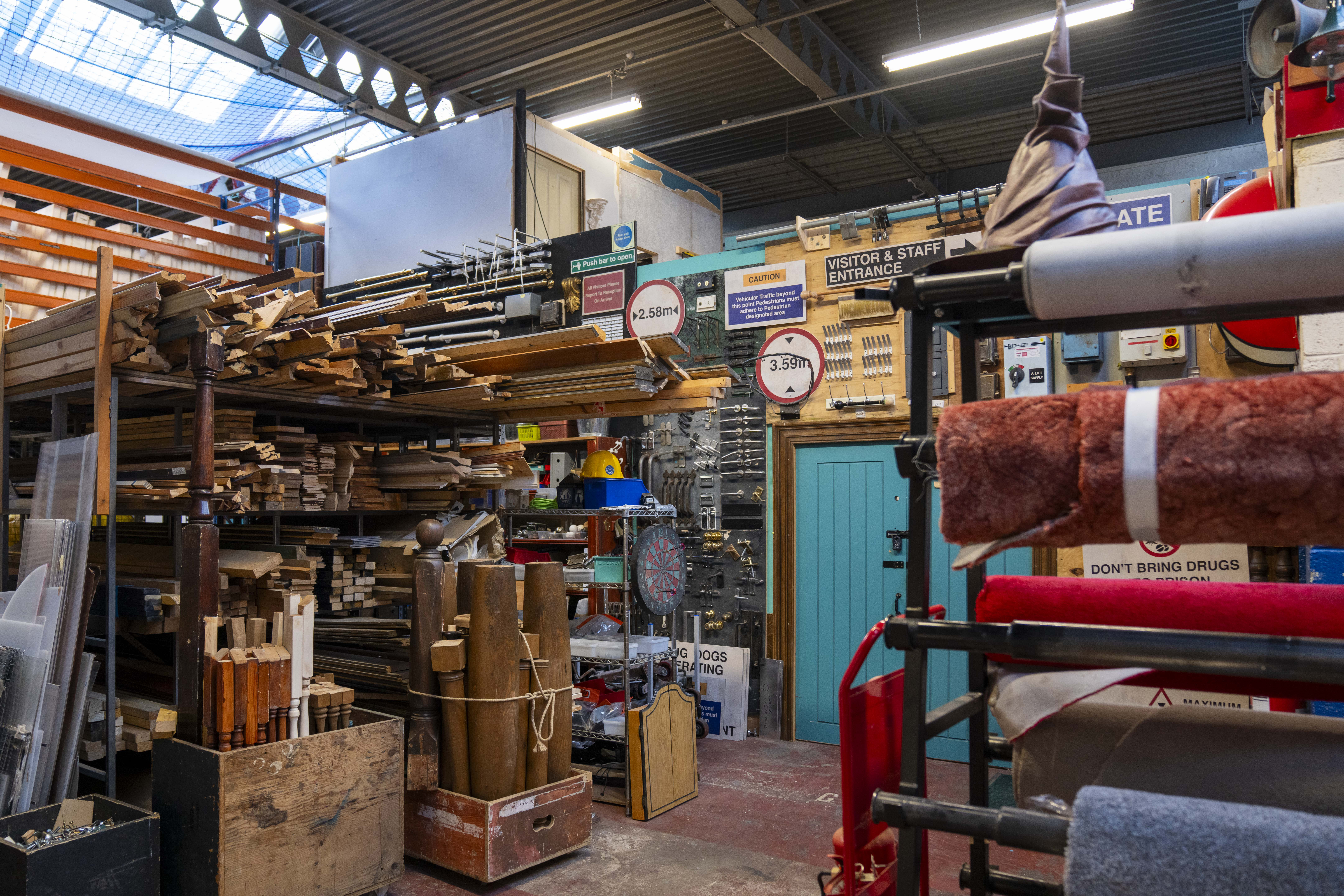 Workshop filled with timber, tools, and signage in an organised storage space.