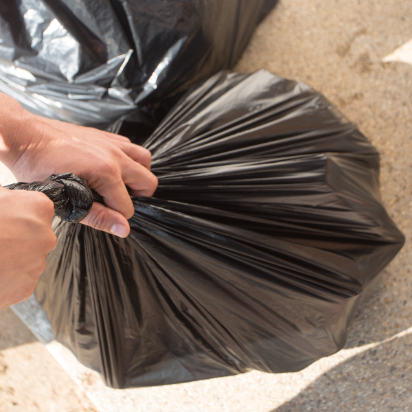 Hands holding a black waste bag