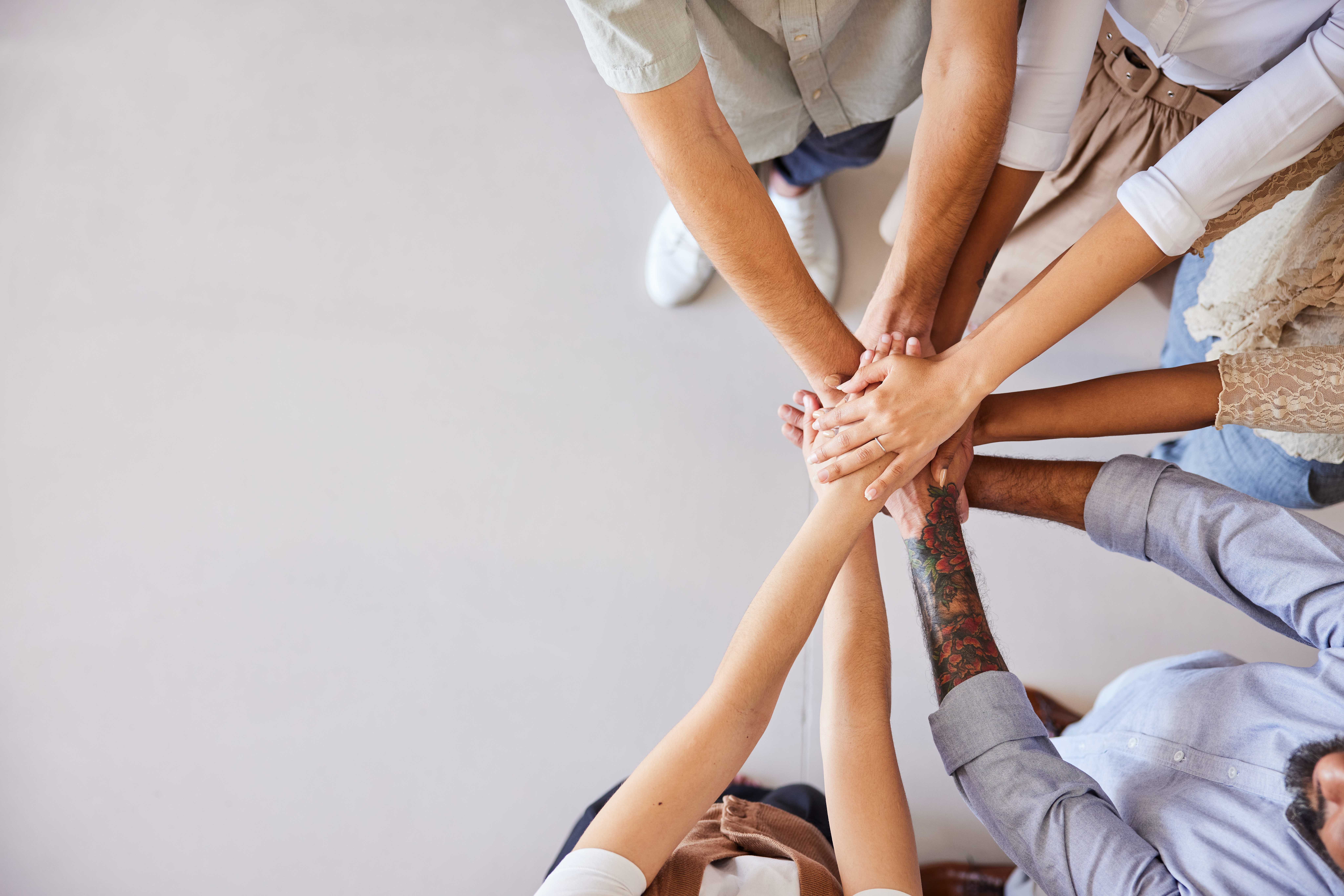 Team members stacking hands together in a circle.