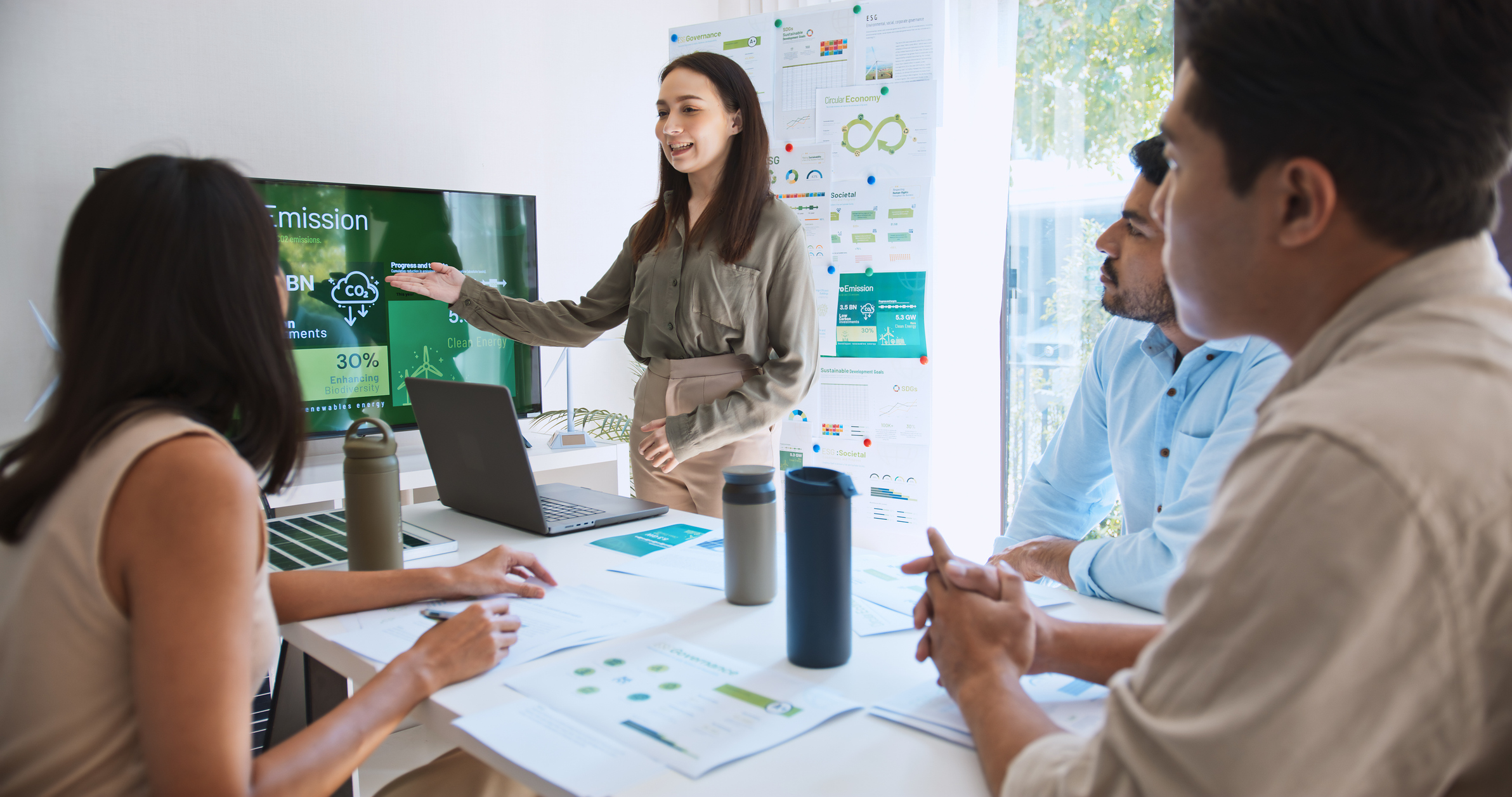 Team meeting discussing sustainability and emissions reduction strategy in an office.