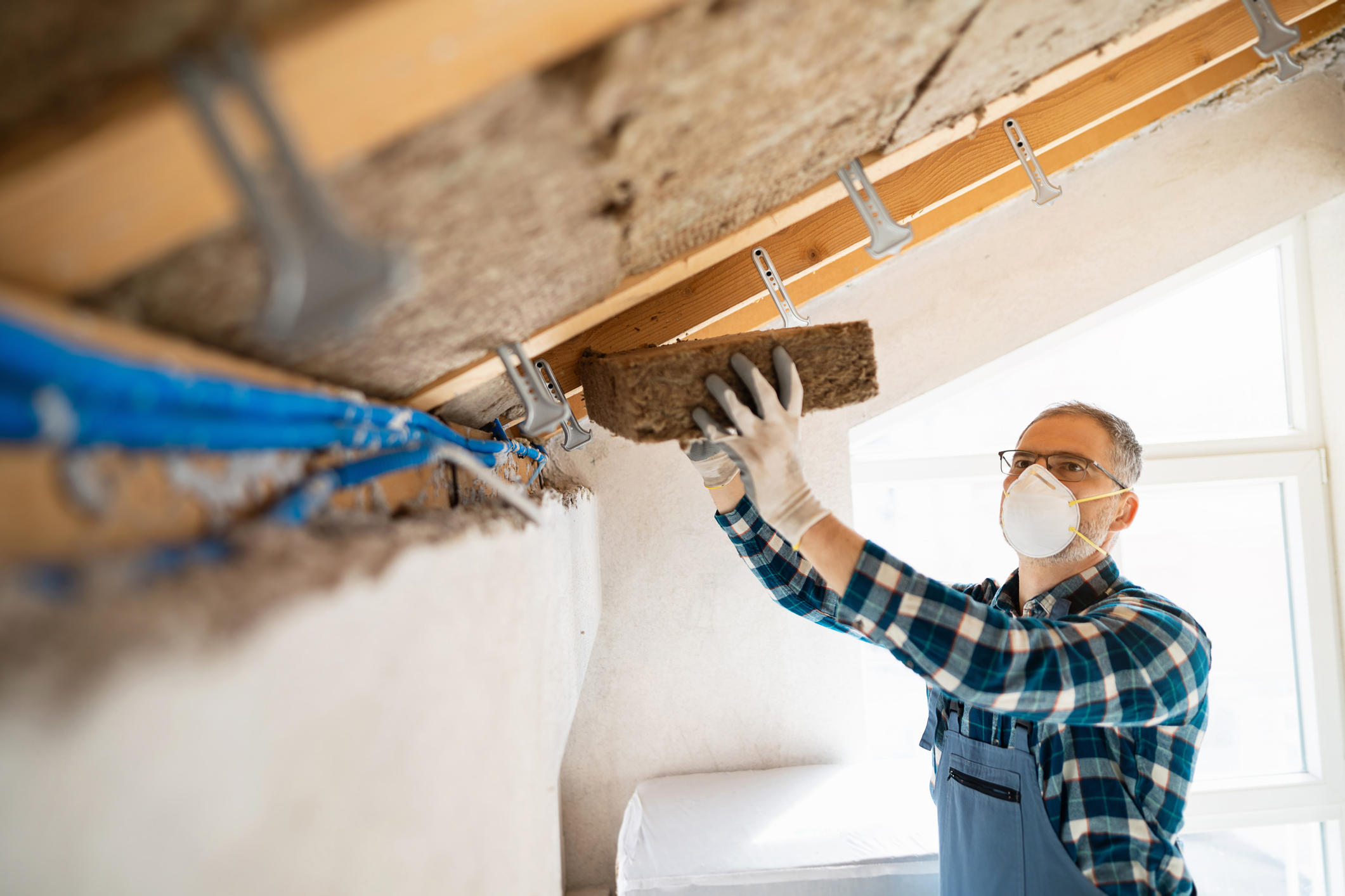 Installing natural fibre insulation in a roof space.